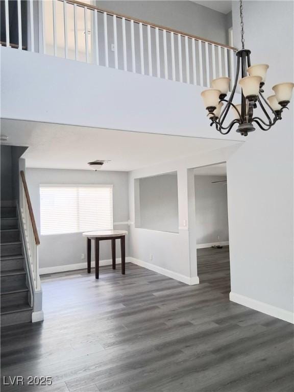 5830 Springmist St, North Las Vegas, NV 89031 - empty room with a chandelier, wood finished floors, baseboards, stairs, and a towering ceiling