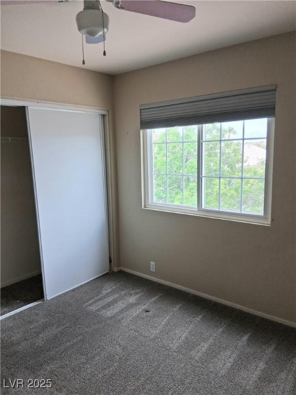 5830 Springmist St, North Las Vegas, NV 89031 - unfurnished bedroom featuring carpet, ceiling fan, a closet, and baseboards