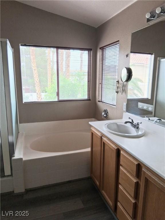 5830 Springmist St, North Las Vegas, NV 89031 - full bathroom featuring a garden tub, vanity, wood finished floors, and a shower stall