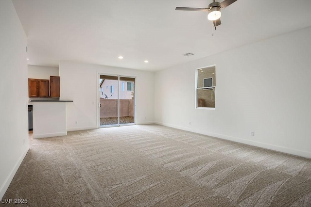 unfurnished living room with light colored carpet and ceiling fan