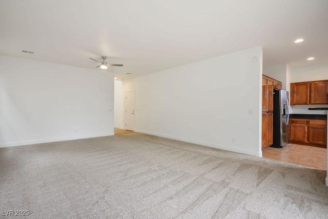 unfurnished living room featuring ceiling fan and light colored carpet