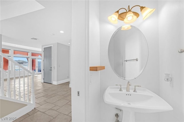 bathroom with baseboards, a sink, and recessed lighting