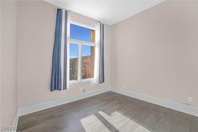 unfurnished room featuring baseboards and wood finished floors