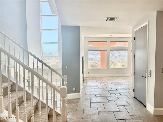 doorway featuring stone finish flooring, plenty of natural light, and baseboards