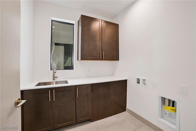 clothes washing area featuring washer hookup, cabinet space, and a sink