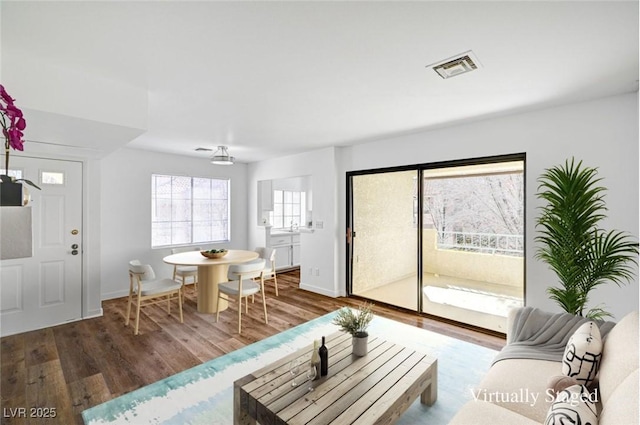 living room featuring baseboards, visible vents, and wood finished floors