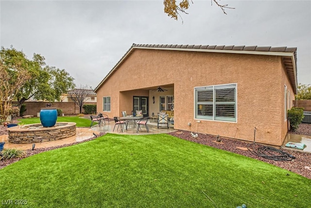 rear view of house featuring a yard, ceiling fan, and a patio area