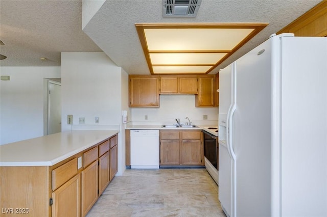 kitchen featuring sink, white appliances, kitchen peninsula, and a textured ceiling