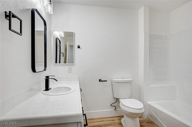 full bathroom featuring wood-type flooring, toilet, shower / washtub combination, and vanity