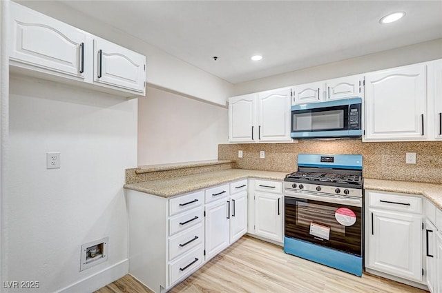 kitchen featuring white cabinetry, light hardwood / wood-style floors, gas stove, and backsplash