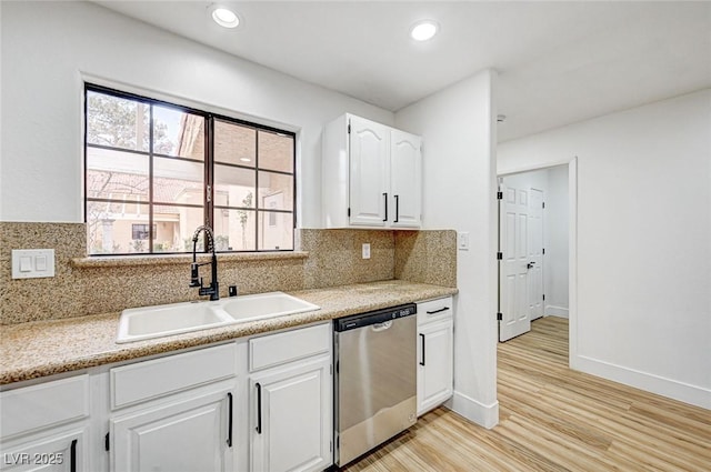 kitchen featuring sink, dishwasher, backsplash, white cabinets, and light wood-type flooring