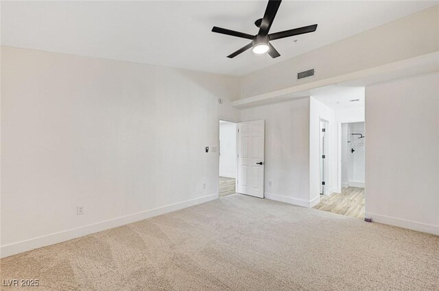 unfurnished bedroom with light colored carpet, ceiling fan, and ensuite bathroom