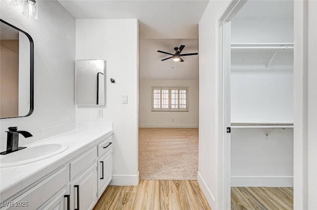 bathroom with ceiling fan, vanity, and hardwood / wood-style floors