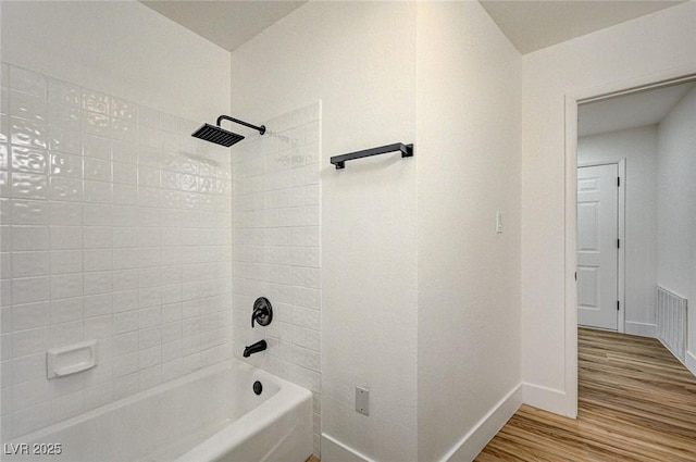 bathroom featuring hardwood / wood-style flooring and tiled shower / bath