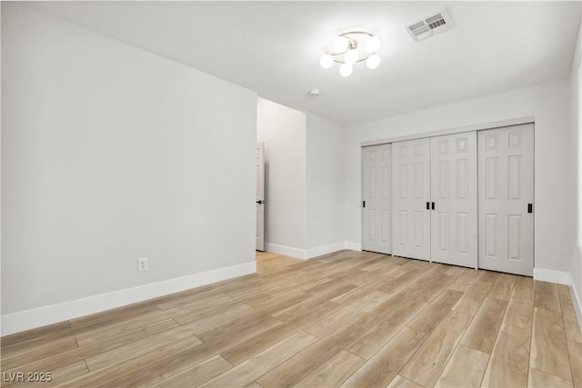 unfurnished bedroom with light wood-type flooring and a closet