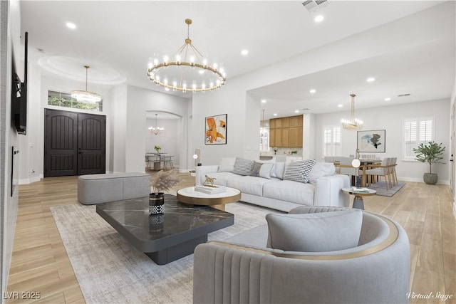 living room featuring a notable chandelier and light hardwood / wood-style flooring