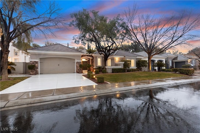 ranch-style home featuring a garage and a lawn