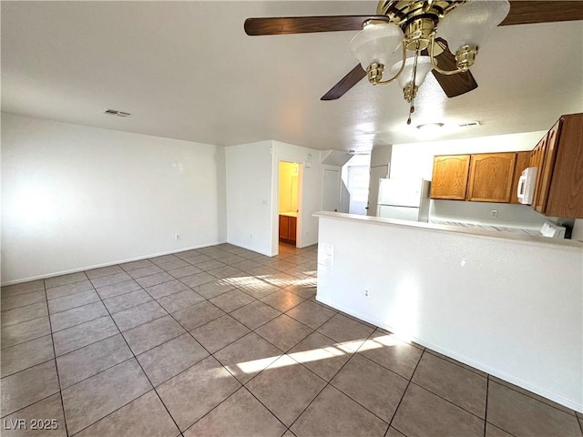 interior space featuring light tile patterned floors and ceiling fan