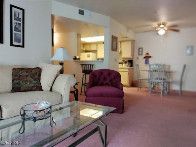 carpeted living room with ceiling fan