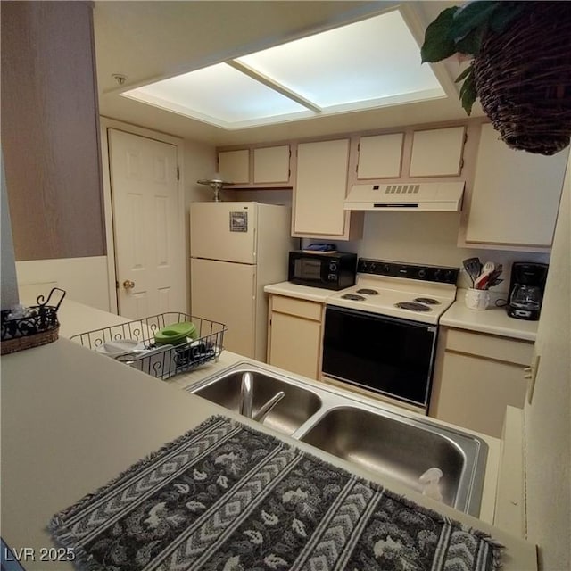 kitchen with sink, white appliances, and cream cabinetry