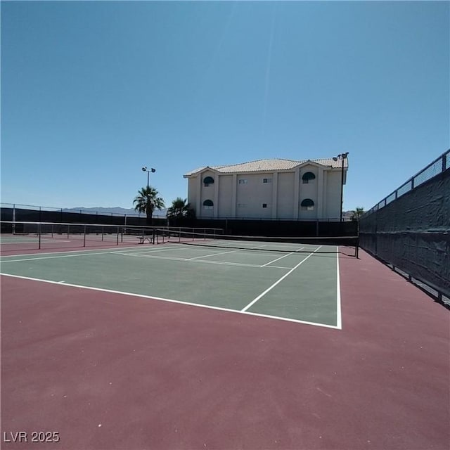 view of tennis court with basketball hoop