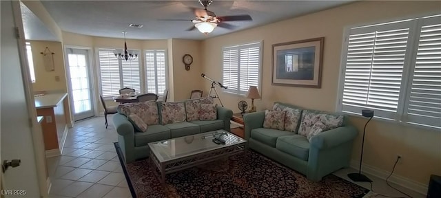 tiled living room featuring ceiling fan with notable chandelier