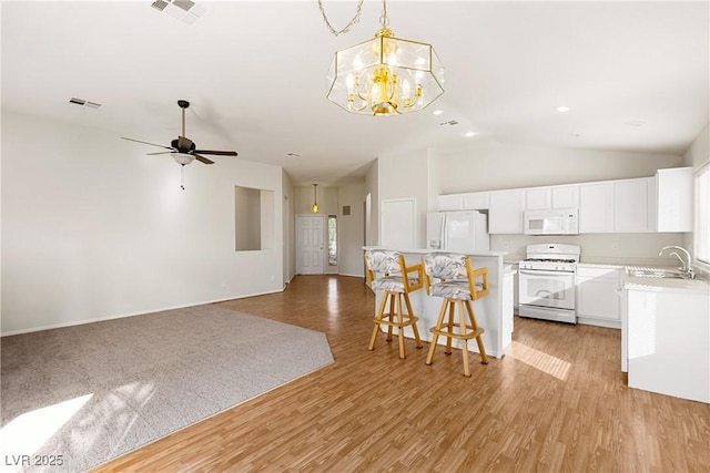 kitchen with sink, a center island, hanging light fixtures, white appliances, and white cabinets