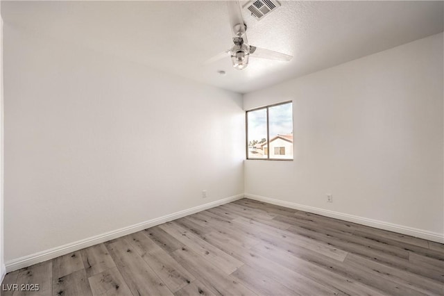 empty room with ceiling fan and light hardwood / wood-style floors