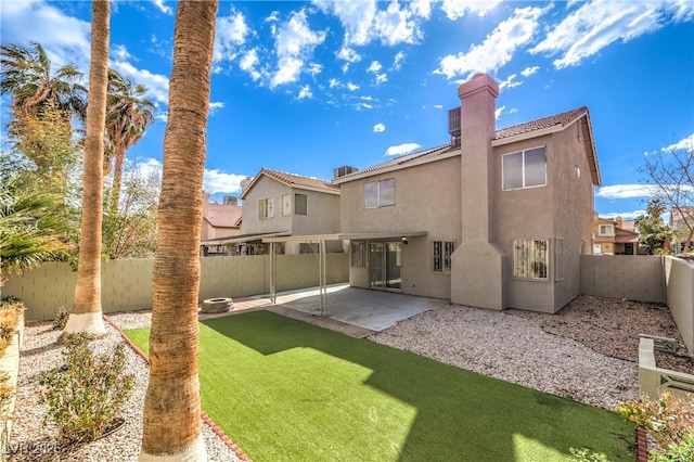 back of property with a yard and a patio area