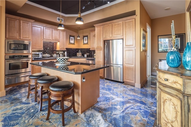 kitchen with a kitchen island, appliances with stainless steel finishes, tasteful backsplash, hanging light fixtures, and a tray ceiling