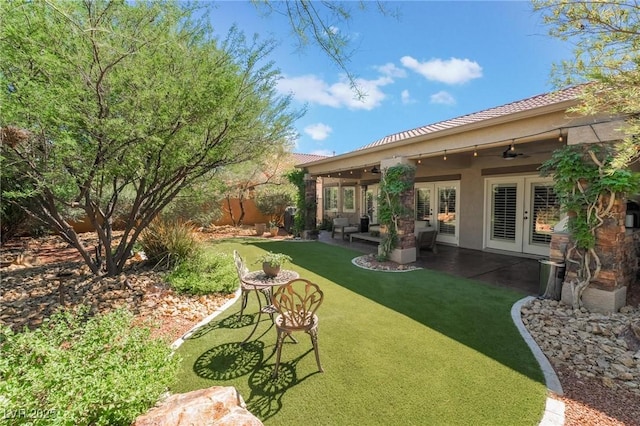 view of yard with french doors, ceiling fan, an outdoor hangout area, and a patio area