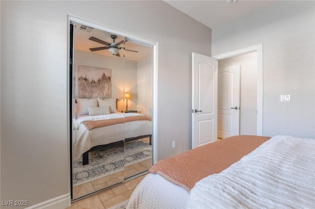 tiled bedroom featuring ceiling fan