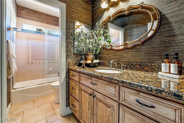 full bathroom with vanity, tiled shower / bath, tile patterned floors, and toilet