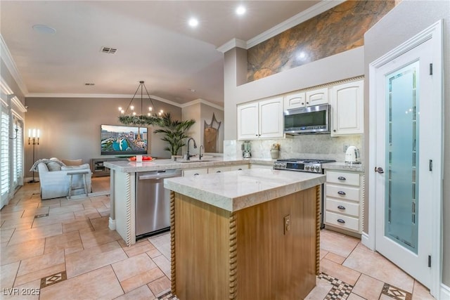 kitchen with sink, kitchen peninsula, a kitchen island, pendant lighting, and stainless steel appliances