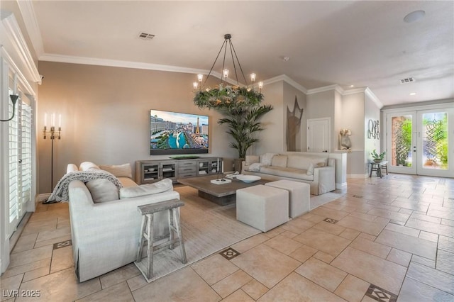 living room with french doors, ornamental molding, and an inviting chandelier