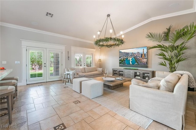 living room with an inviting chandelier, ornamental molding, french doors, and lofted ceiling