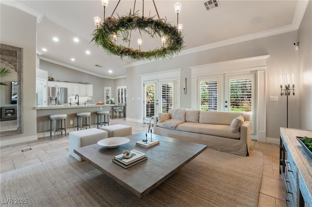 living room featuring crown molding, sink, light tile patterned flooring, and french doors