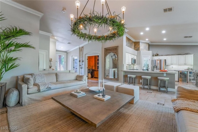 living room featuring an inviting chandelier, wine cooler, and ornamental molding