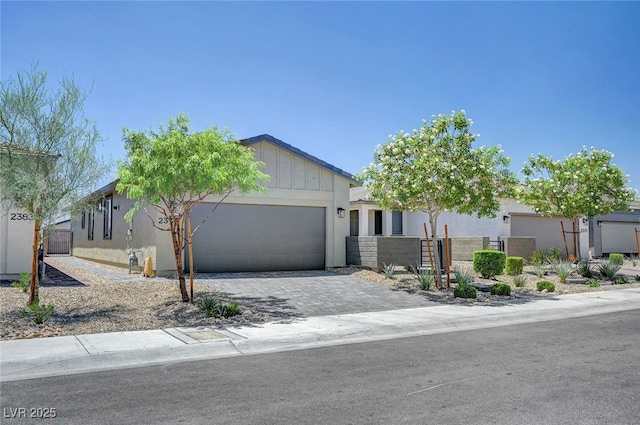 2379 Albury Ave, North Las Vegas, NV 89086 - view of front of house with a garage, driveway, board and batten siding, and stucco siding