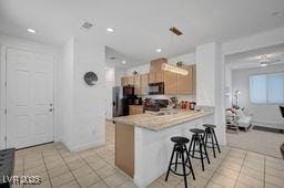 2379 Albury Ave, North Las Vegas, NV 89086 - kitchen featuring light tile patterned floors, a kitchen breakfast bar, light countertops, a peninsula, and recessed lighting