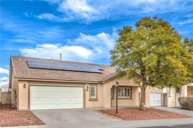 ranch-style house featuring a garage and solar panels