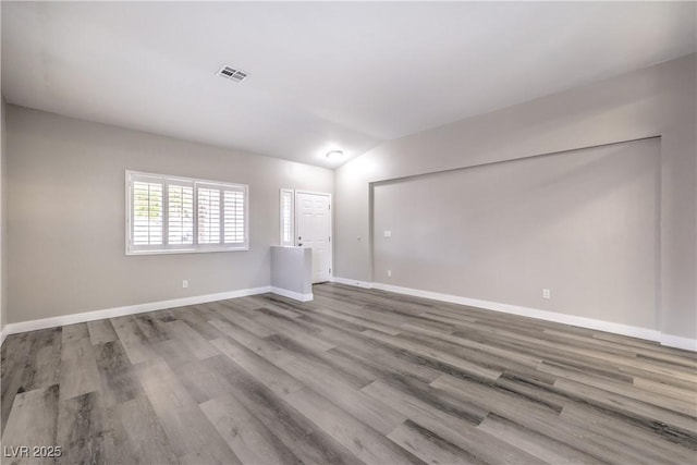 empty room with lofted ceiling and light hardwood / wood-style floors