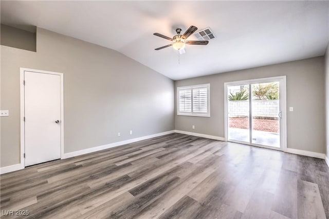 spare room with ceiling fan, vaulted ceiling, and wood-type flooring