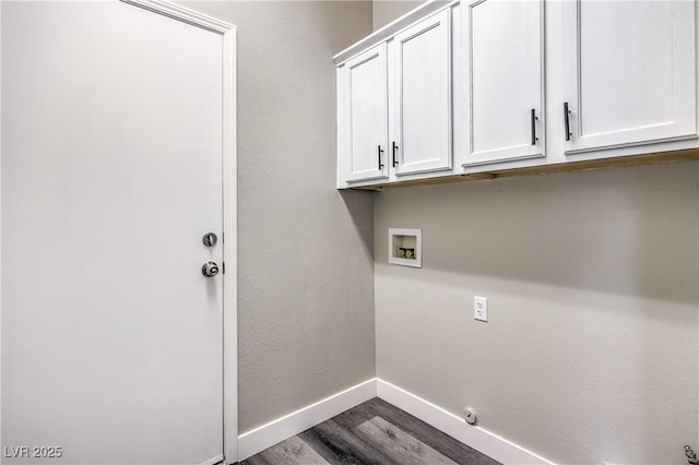 clothes washing area featuring cabinets, hardwood / wood-style floors, and washer hookup