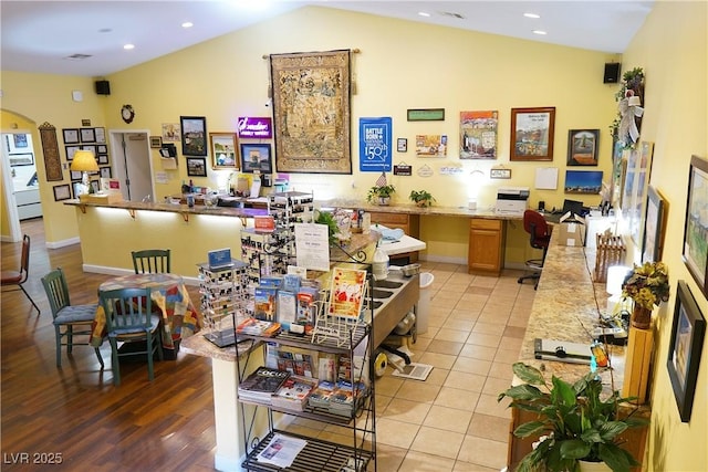 interior space with light tile patterned floors and vaulted ceiling