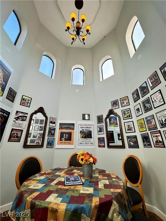 dining room with a chandelier and a high ceiling