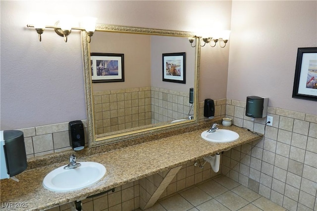 bathroom featuring tile patterned flooring, sink, and tile walls