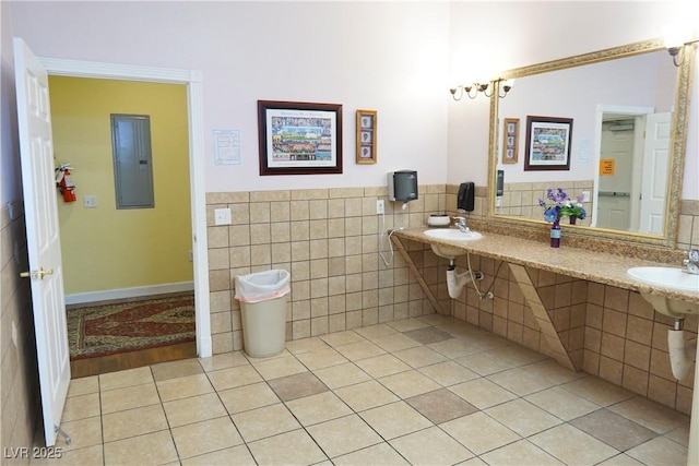 bathroom featuring tile walls, tile patterned flooring, electric panel, and dual sinks