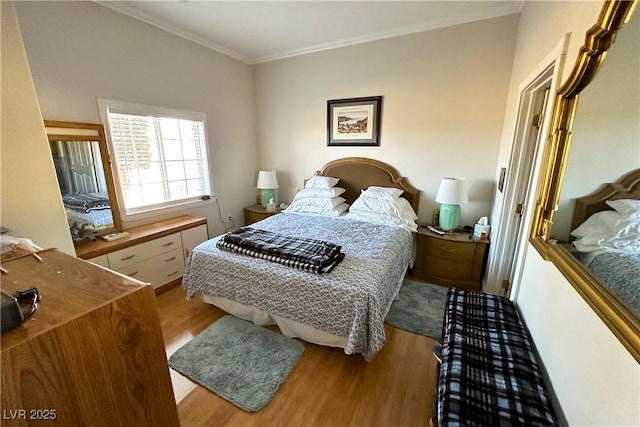 bedroom featuring ornamental molding and light hardwood / wood-style floors