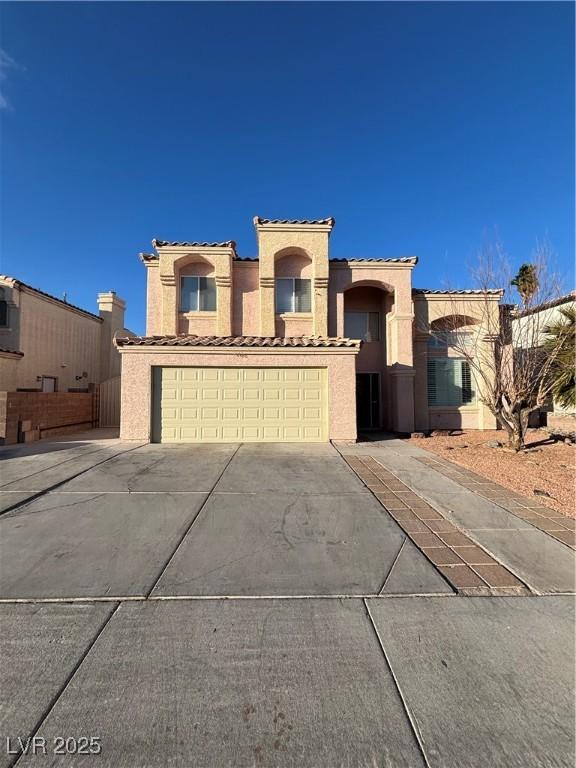 mediterranean / spanish-style home with a garage